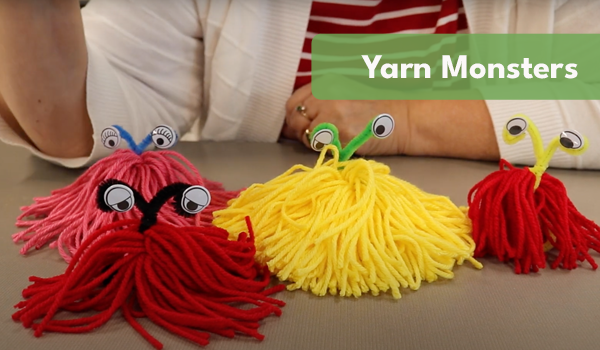 Photo of four yarn monster crafts in red and yellow.