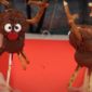 Two chocolate covered marshmallows, decorated to look like reindeers with pretzel antlers, a red button nose, and eyes, are held up by wooden skewers.